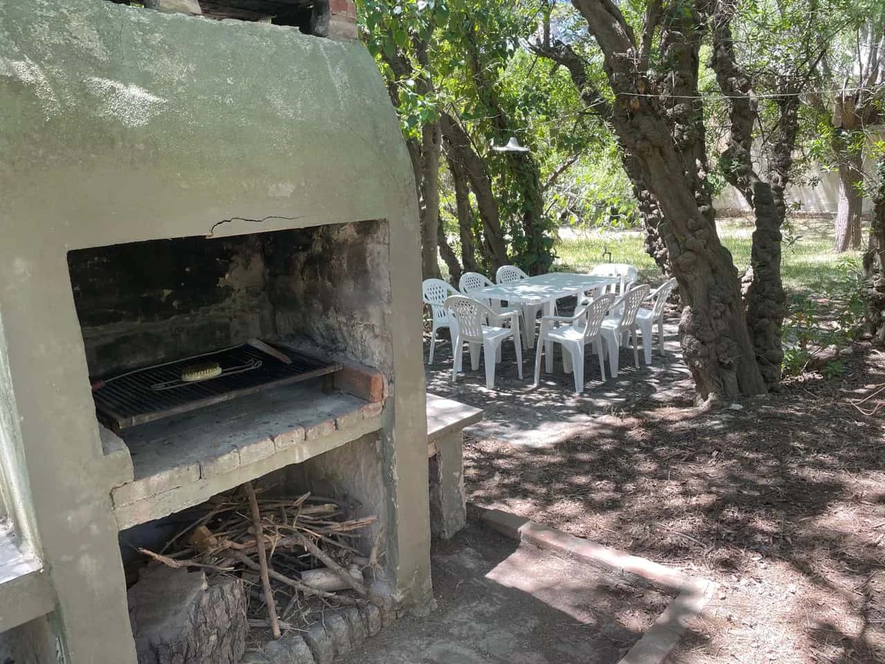 Parrilla con mesas y sillas de jardín en Balneario Reta